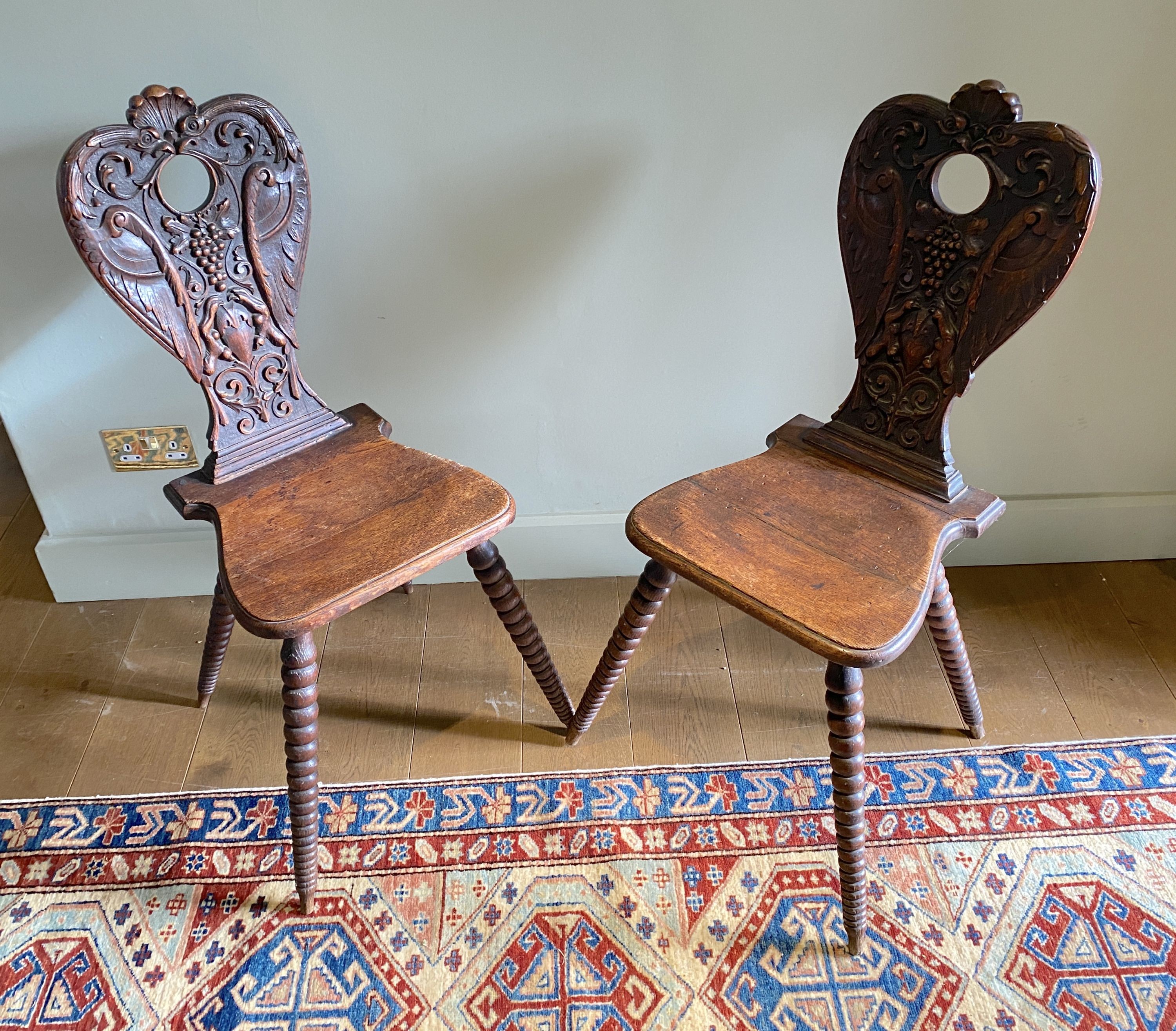 A pair of 19th century Swiss carved oak hall chairs, with vine and scroll backs and tapered bobbin turned legs, width 55cm height 98cm